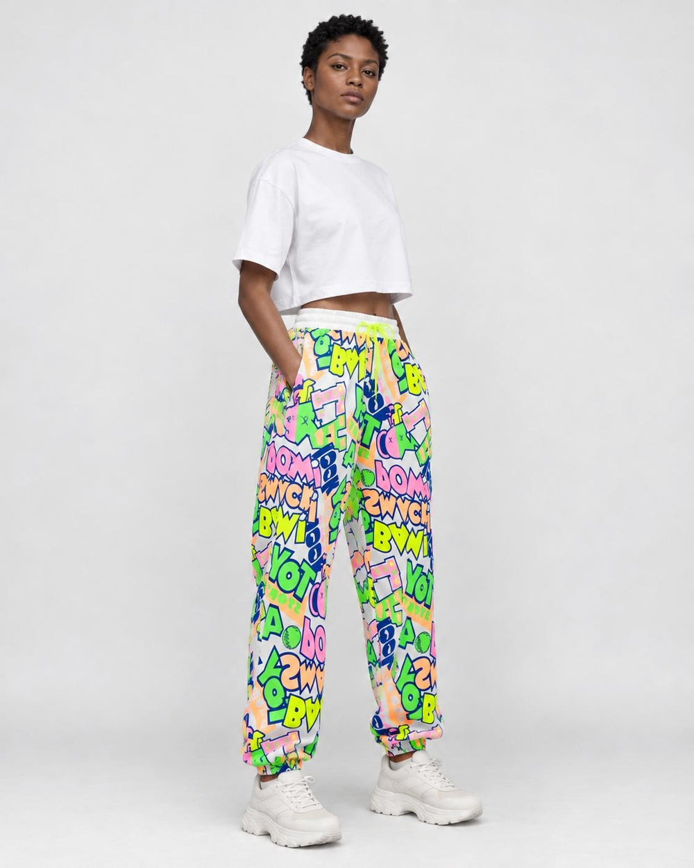 Model wearing the white-ground graffiti pants, three-quarter view