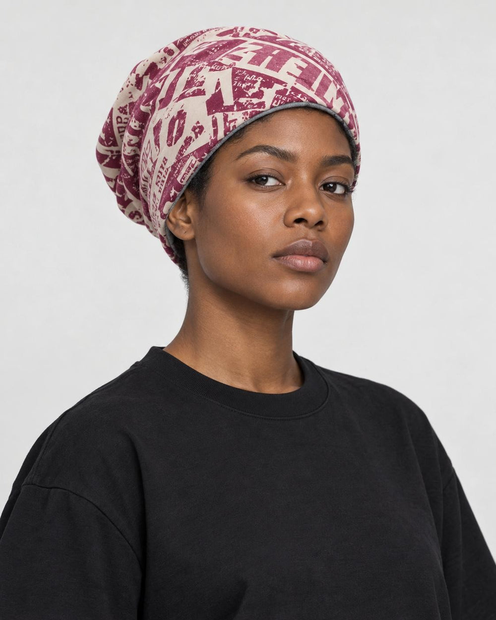 Model wearing the wine red newsprint slouchy beanie, three-quarter view