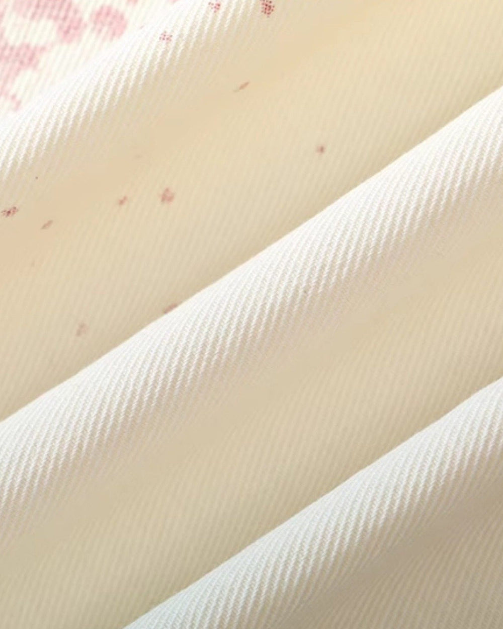 Close-up of the cream twill with small pink splatter specks