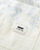 Close-up of the chest pocket and its small woven label on the cream twill