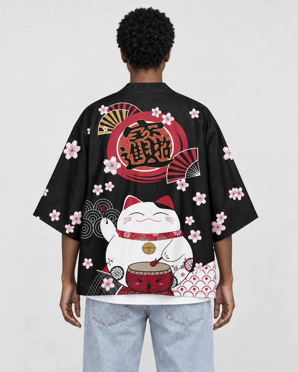 Woman seen from behind in a black haori with a white lucky cat, a red drum and cherry blossoms on the back