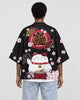 Woman seen from behind in a black haori with a white lucky cat, a red drum and cherry blossoms on the back