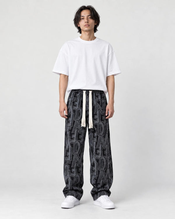 Model wearing the black outline letter corduroy pants with a black tee, front view