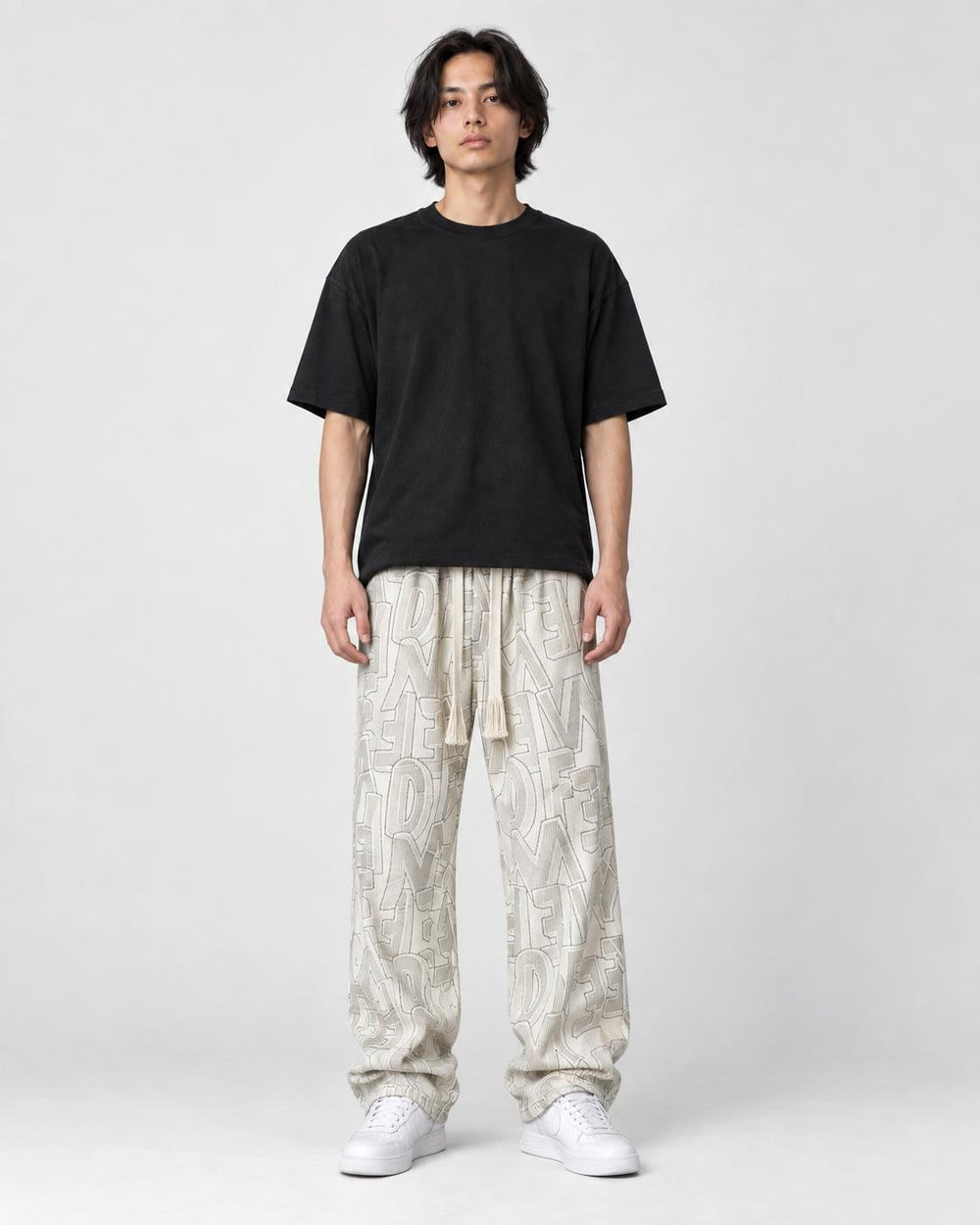 Model wearing the cream outline letter corduroy pants, front view