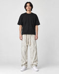 Model wearing the cream outline letter corduroy pants, front view