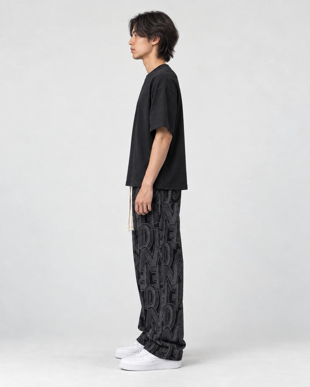 Model wearing the black letter corduroy pants, side view