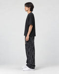 Model wearing the black letter corduroy pants, side view