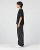 Model wearing the black letter corduroy pants, side view