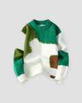Green patchwork cable knit sweater, front view, cream base with green and brown patches