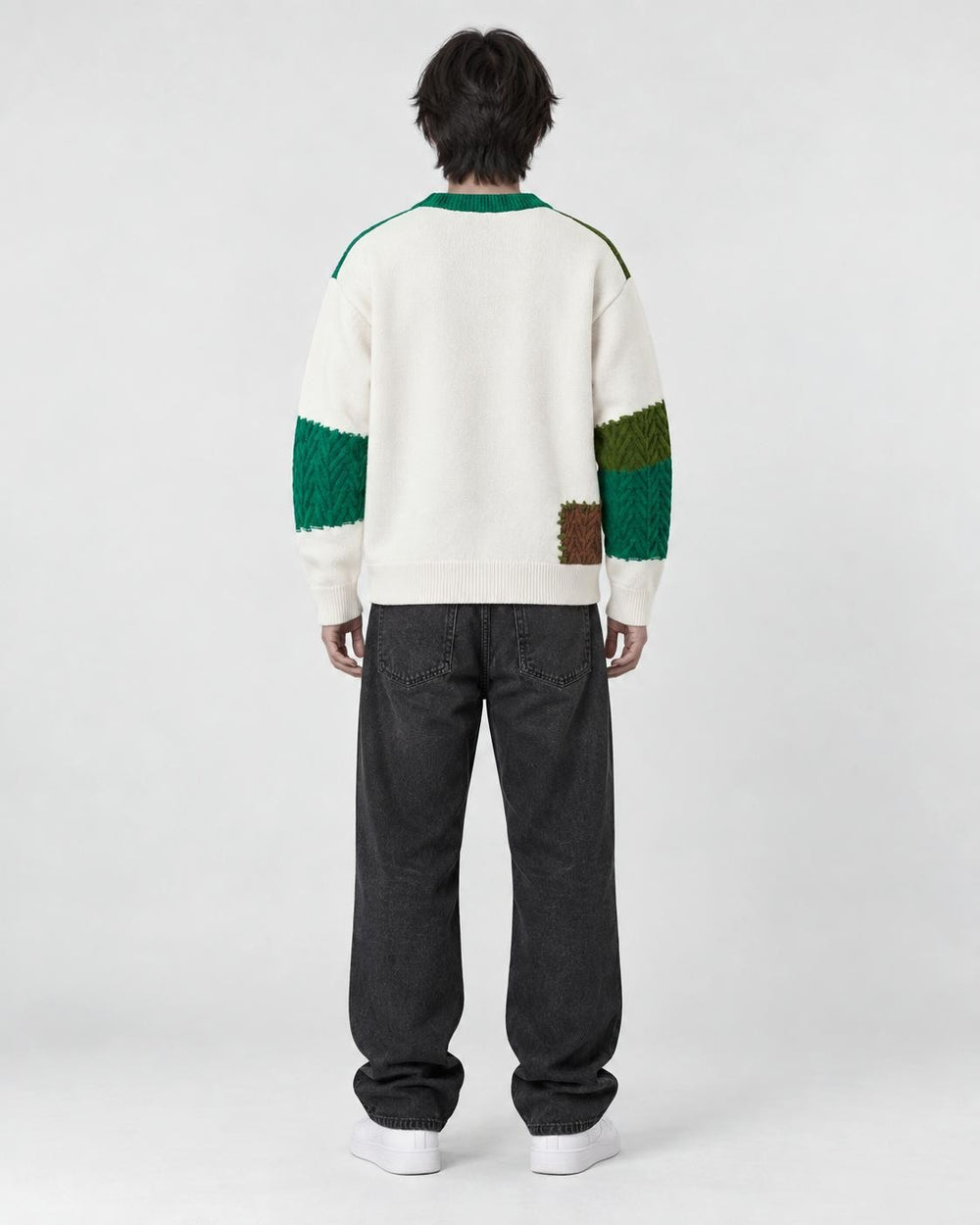 Model wearing the green patchwork cable knit sweater, back view