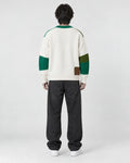 Model wearing the green patchwork cable knit sweater, back view
