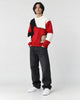 Model wearing the red patchwork cable knit sweater, three-quarter view