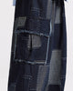 Close view of the raw-edged flap pocket and gray-blue patches on the indigo cargo pants