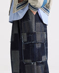 Side view of the indigo patchwork cargo pants with the wide straight leg and flap pocket