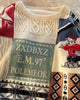 Close-up of the lettered patch and jacquard bands on the cream patchwork sweater