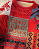 Close-up of the lettered patch and cartoon figure on the red patchwork sweater