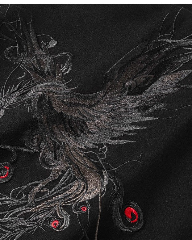 Close-up of the grey phoenix embroidery with red accents on the black T-shirt