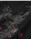 Close-up of the grey phoenix embroidery with red accents on the black T-shirt
