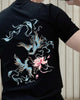 Close-up of the pale blue phoenixes and pink lotus printed on the back of the black tee