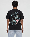 Model wearing the black phoenix and lotus print T-shirt with light-wash jeans, back view