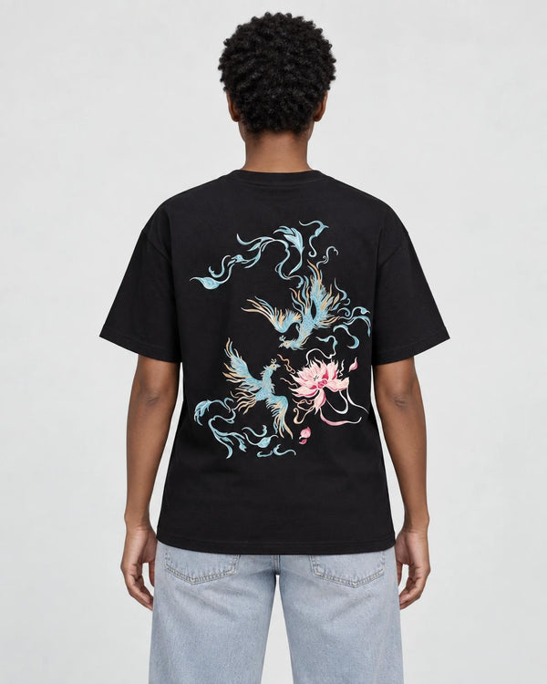 Model wearing the black phoenix and lotus print T-shirt with light-wash jeans, back view