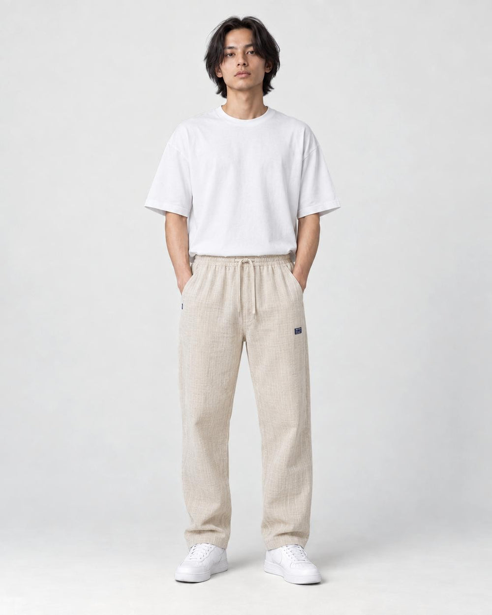 Model wearing the beige pinstripe drawstring pants, front view