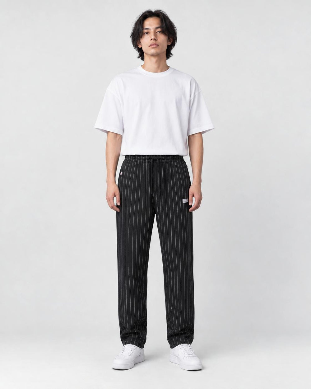 Model wearing the black pinstripe drawstring pants, front view