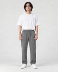 Model wearing the gray pinstripe drawstring pants with a white tee, front view