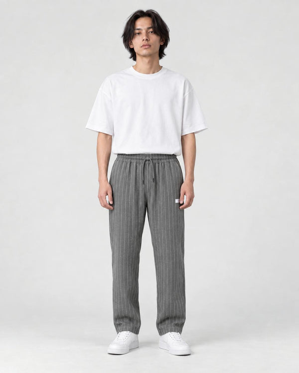 Model wearing the gray pinstripe drawstring pants with a white tee, front view