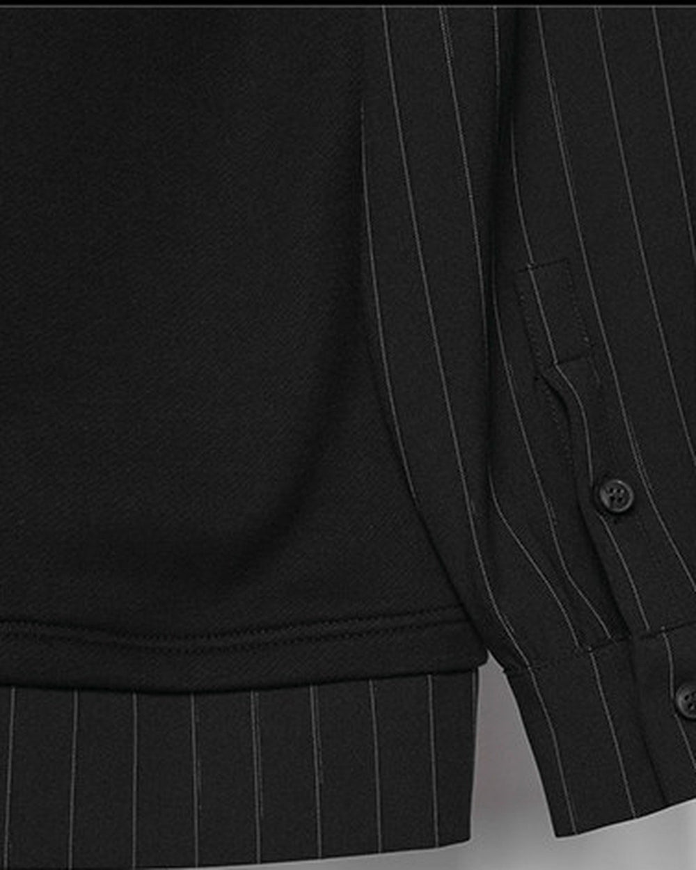 Close-up of the buttoned pinstripe cuff and striped hem band