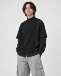 Model wearing the layered mock neck sweatshirt with light gray cargo trousers, three-quarter view