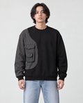 Model wearing the black pinstripe panel crewneck sweatshirt with light-wash jeans, front view