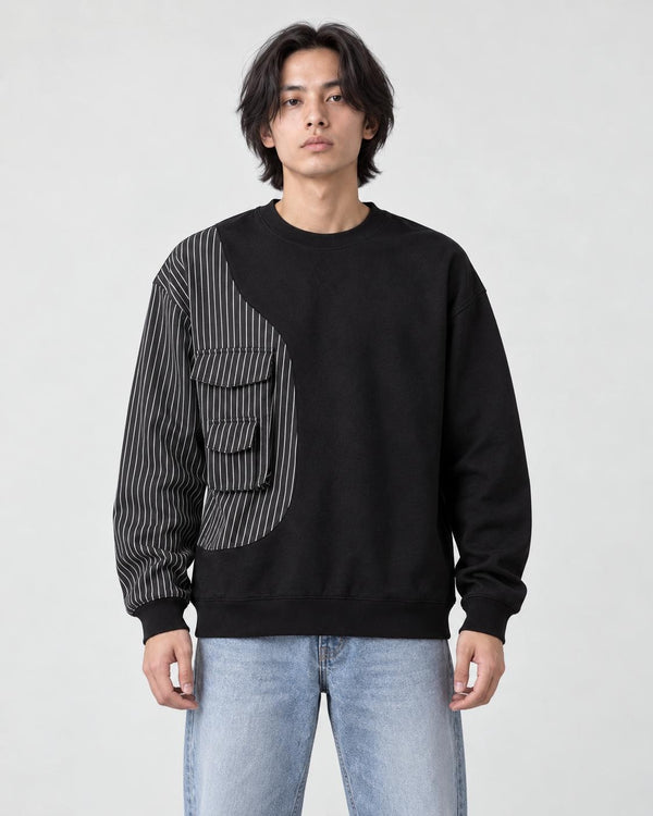 Model wearing the black pinstripe panel crewneck sweatshirt with light-wash jeans, front view