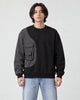 Model wearing the black pinstripe panel crewneck sweatshirt with light-wash jeans, front view