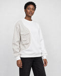 Model wearing the white pinstripe panel crewneck sweatshirt with black jeans, three-quarter view