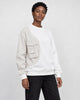 Model wearing the white pinstripe panel crewneck sweatshirt with black jeans, three-quarter view