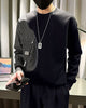 Close view of the black sweatshirt's pinstripe panel, flap pockets and small woven label