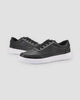 Pair of black low-top platform sneakers with a thick ridged white sole, three-quarter view