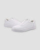 Pair of white low-top platform sneakers with a thick ridged white sole, three-quarter view