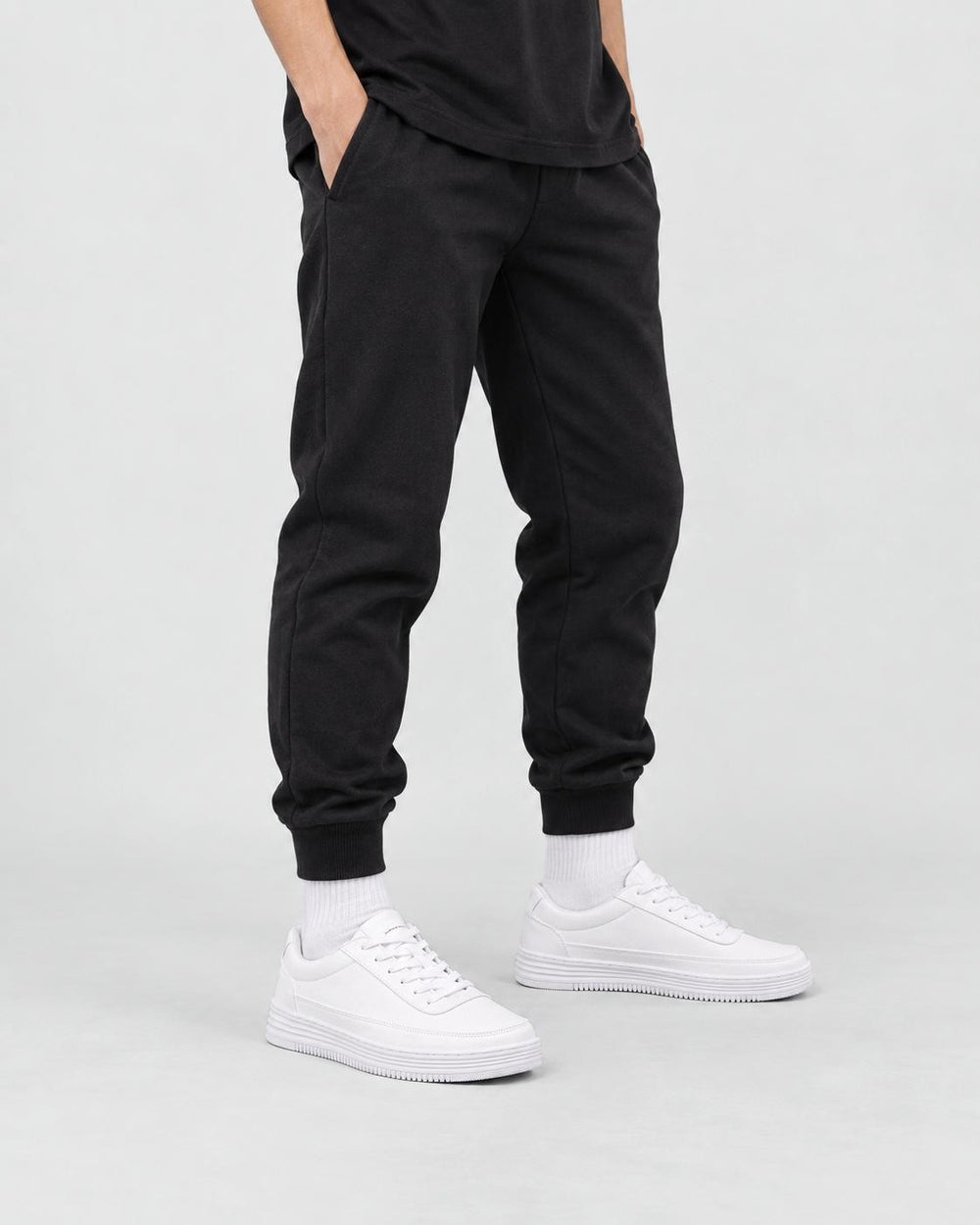Model wearing the white platform sneakers with slim black pants and white socks, from the hips down