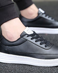 Black platform sneakers on foot, showing the FASHION label on the tongue and the white ridged sole