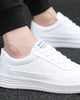 White platform sneakers on foot, showing the FASHION label on the tongue and the ridged sole
