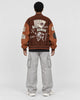 Model wearing the brown playing card patch varsity jacket, back view of the card and lettering artwork