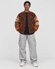 Model wearing the brown playing card patch varsity jacket, front view with B and C letters