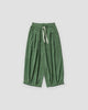 Green pleated corduroy wide-leg pants, front view, cream drawstring and gathered hem