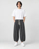 Model wearing the gray pleated corduroy wide-leg pants with a white tee, front view