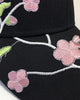 Close-up of the pink plum blossoms and green leaves embroidered on the brim