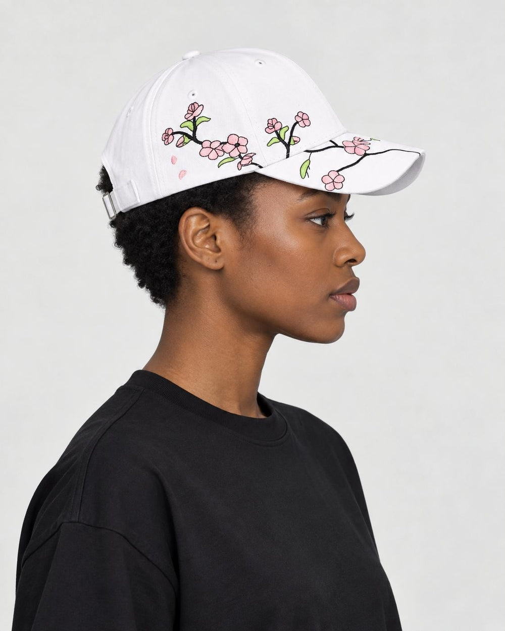 Model wearing the white plum blossom cap, side view of the embroidered branch