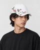 Model wearing the white plum blossom embroidered baseball cap, three-quarter view