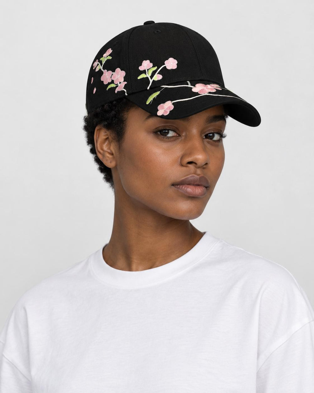 Model wearing the black plum blossom cap, three-quarter view